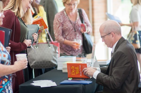 Funny speaker Ron Culberson signs books at a conference.
